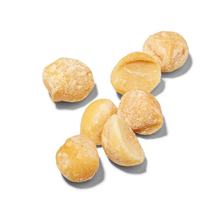 A group of shelled macadamia nuts scattered on a white surface.