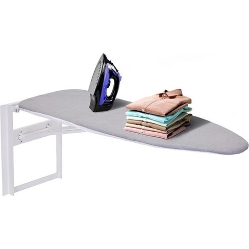Woman ironing cloth with portable travel iron on ironing board