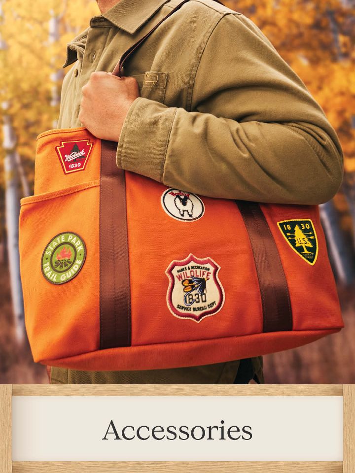 Accessories – 
image features orange canvas tote with logo patches and a brown strap