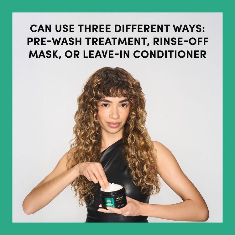 A person holding a black jar of hair product with text above stating it can be used as a pre-wash treatment, rinse-off mask, or leave-in conditioner.