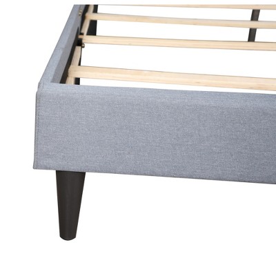 Close-up of bed frame corner showing fabric and slat support