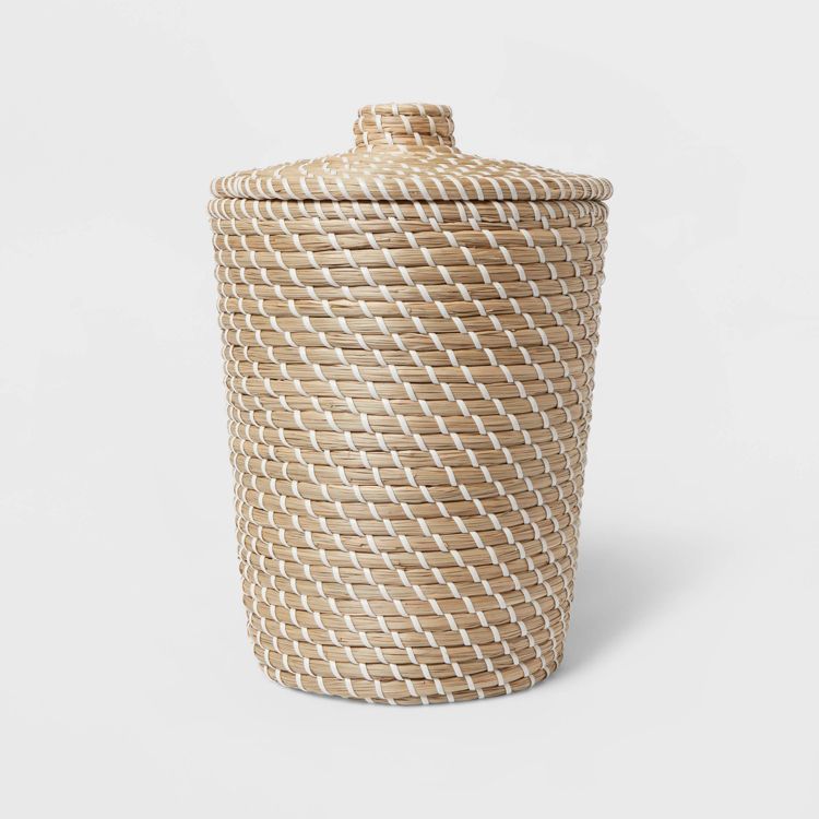 A cylindrical wastebasket with a lid, featuring a woven pattern in beige and white colored materials.