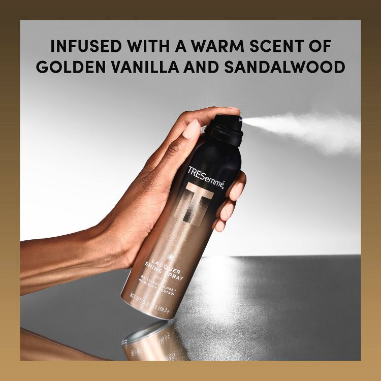 A hand holding a black and brown colored TRESemmé hairspray can, with text above reading "INFUSED WITH A WARM SCENT OF GOLDEN VANILLA AND SANDALWOOD."