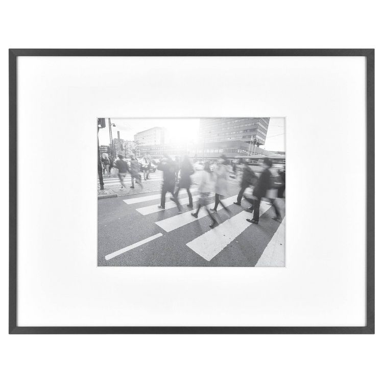 A black frame with a black and white photo of people crossing a street at a crosswalk.