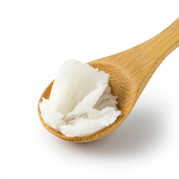 A wooden spoon containing a scoop of solid white colored oil.