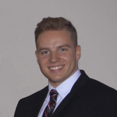 Target engineer Liam Robinson pictured smiling, wearing a shirt and tie and suit jacket against a neutral background