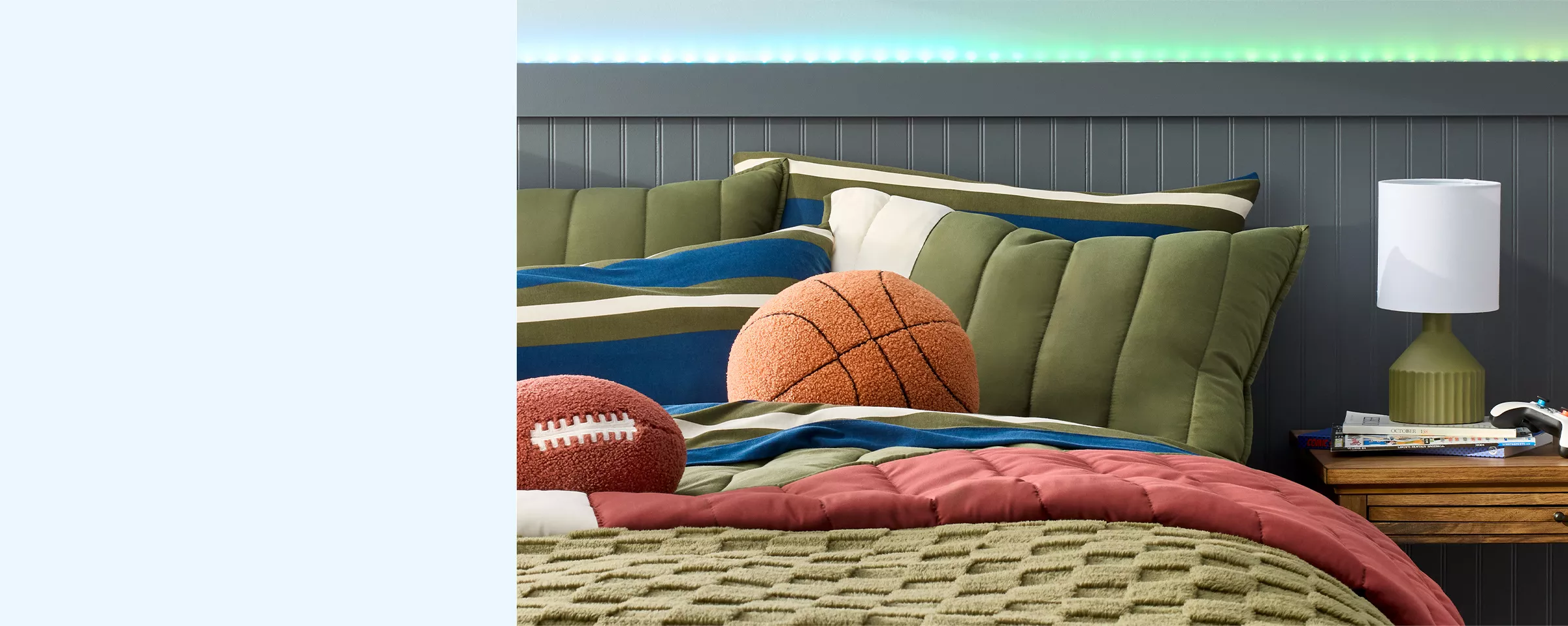 A color block patterned bed spread with deep greens, blues & white, is the focus. A fuzzy football & basketball shaped pillow rest on top of the bed. A mix of textures makes this space cozy, yet the dark colors bring out a masculine edge. 