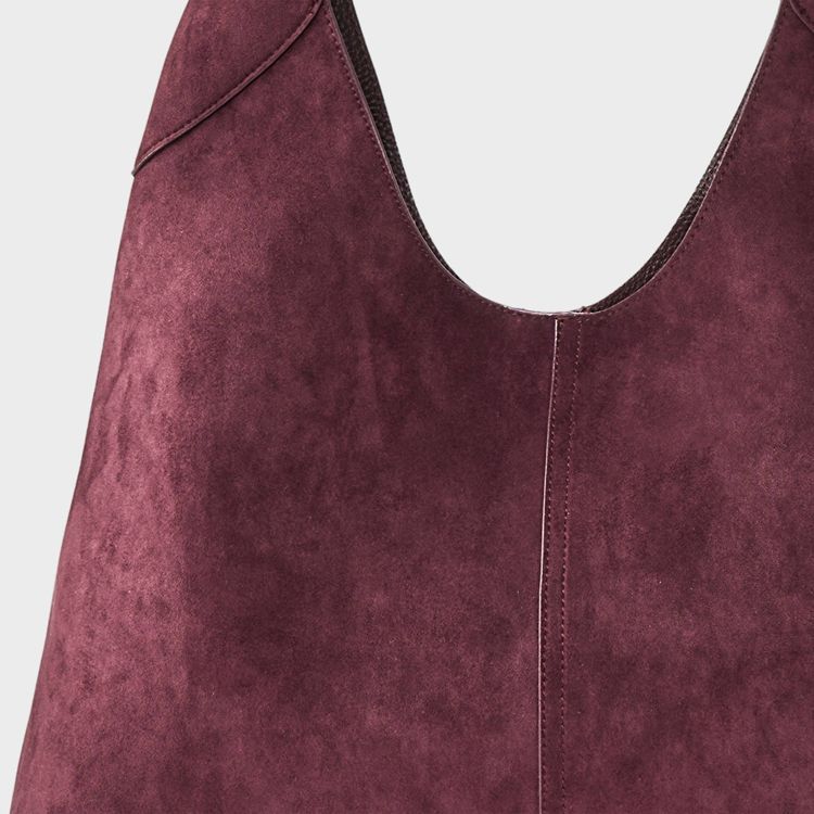 A burgundy colored bag with a textured surface and visible stitching.