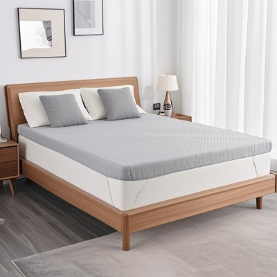 Twin bed with thicker foam mattress on wooden frame and white/gray bedding