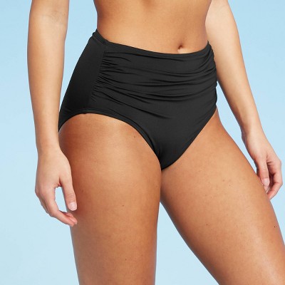 girl putting on one piece swimsuit