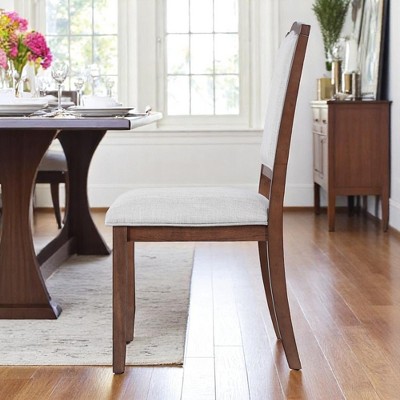 Side profile of an upholstered dining chair at a dining table