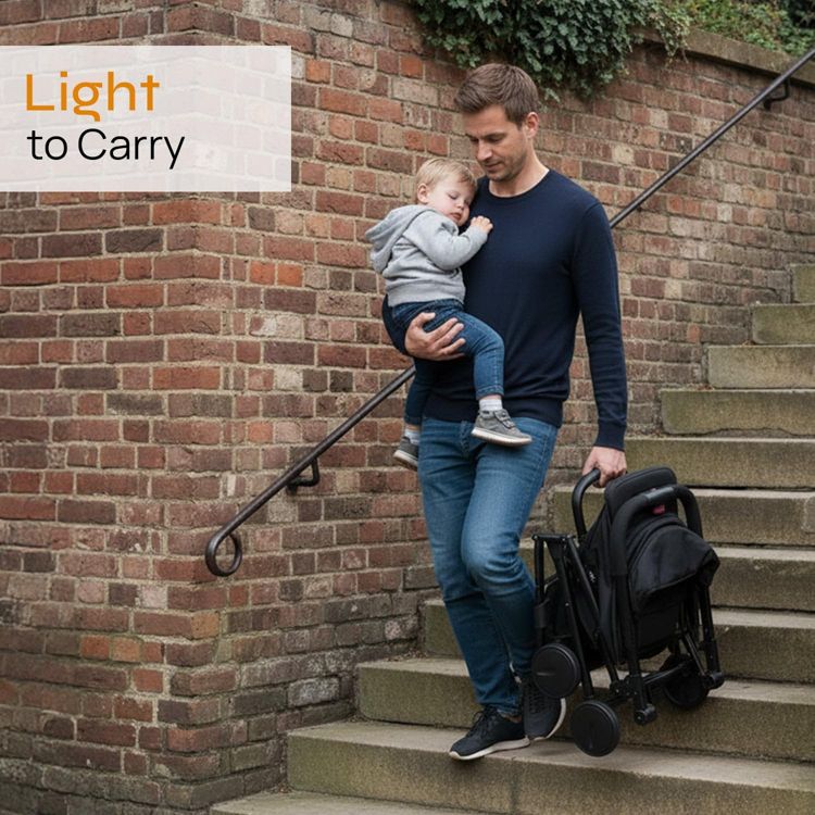 A person carrying a folded black colored stroller while walking down stairs.