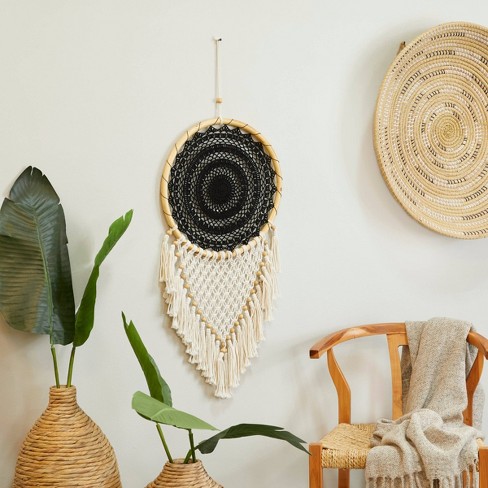 Hand woven black macrame with white beads hanging on wall Stock