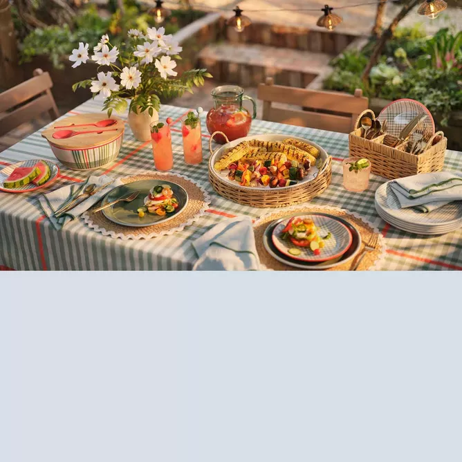 Backyard dining with scalloped, wicker and plaid details.