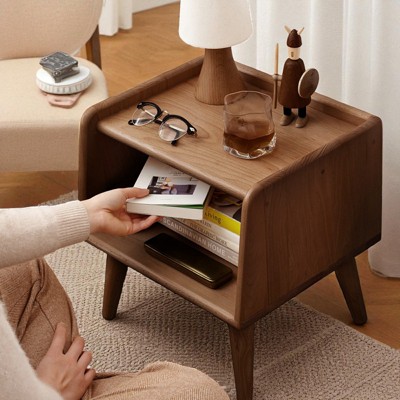 Bedside cabinet with shelf open and items including sunglasses, drinks, and phone