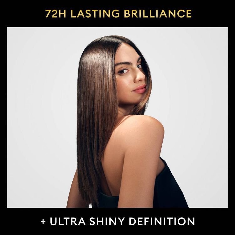 A woman with sleek, straight hair wearing a black top, showcasing ultra-shiny, defined hair. Text reads: "72H LASTING BRILLIANCE" and "+ ULTRA SHINY DEFINITION." The image evokes a sense of elegance and high-quality hair care.