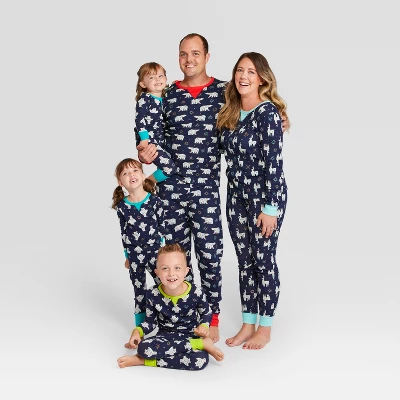 An image of a man, woman, and 3 children wearing navy pajamas with white animals printed on them.