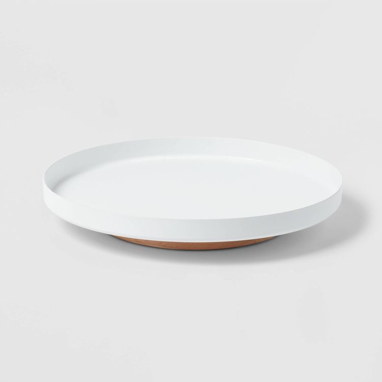 A round white colored organizer tray with a wooden base.