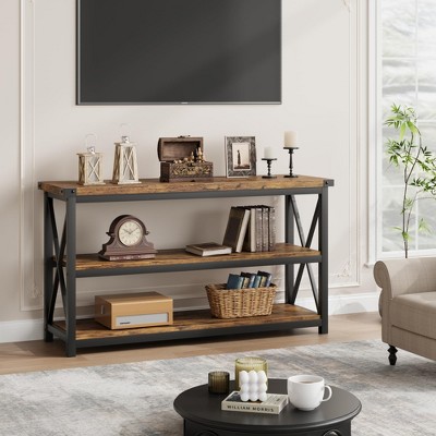 Console table in a living room with TV mounted above and decorative items on shelves