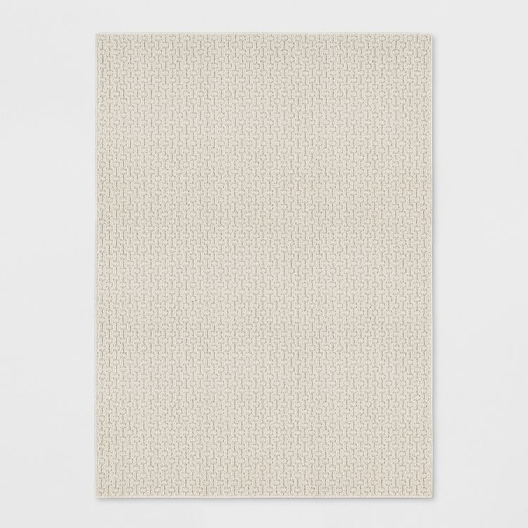 A beige colored rug with a subtle textured pattern on a white background.