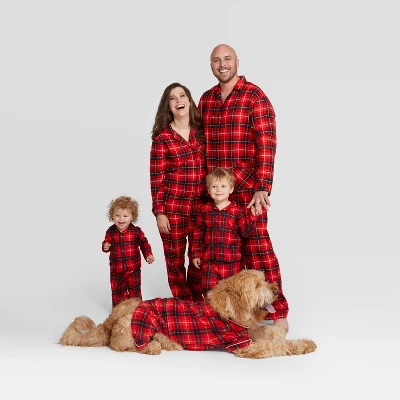 image of a woman, man, dog, and 2 children wearing matching red plaid pajamas. 