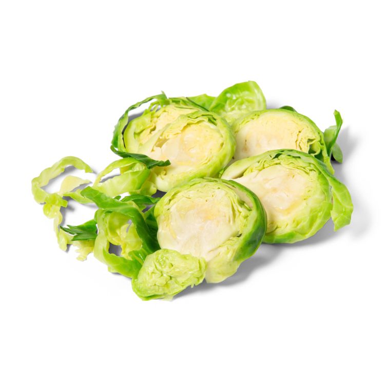 Halved Brussels sprouts with light green colored leaves on a white background.
