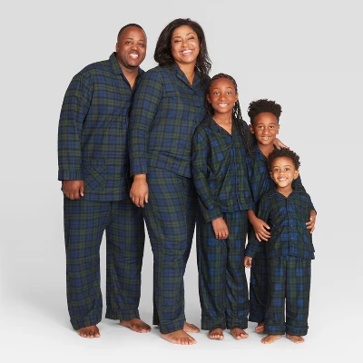 An image of a man, woman, and 3 children wearing navy and green plaid pajamas.