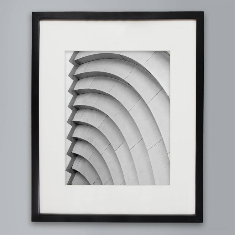 A black colored frame with a black and white abstract architectural photo featuring curved lines.