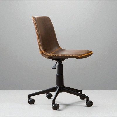 Side view of brown leather swivel office chair on casters