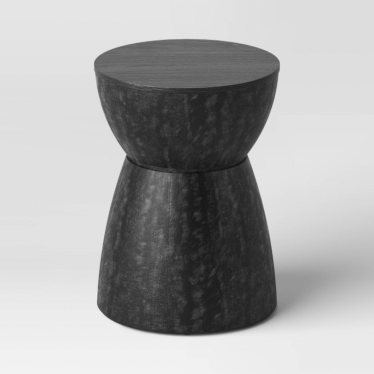 A black colored, hourglass-shaped end table with a smooth top surface.