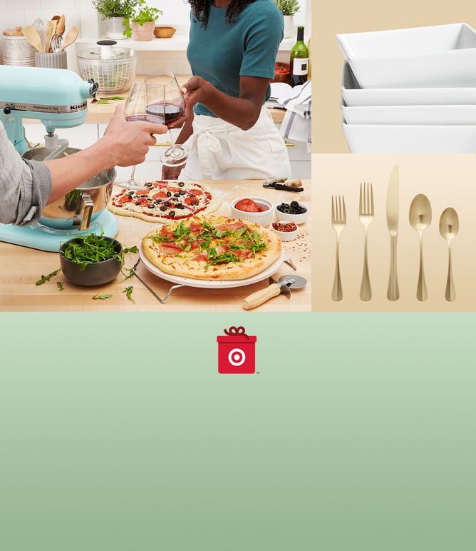 Couple cheers after making homemade pizzas. Silverware and bowls in view. 